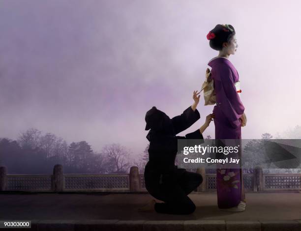 geisha having her kimono fixed by a servant - coneyl - fotografias e filmes do acervo