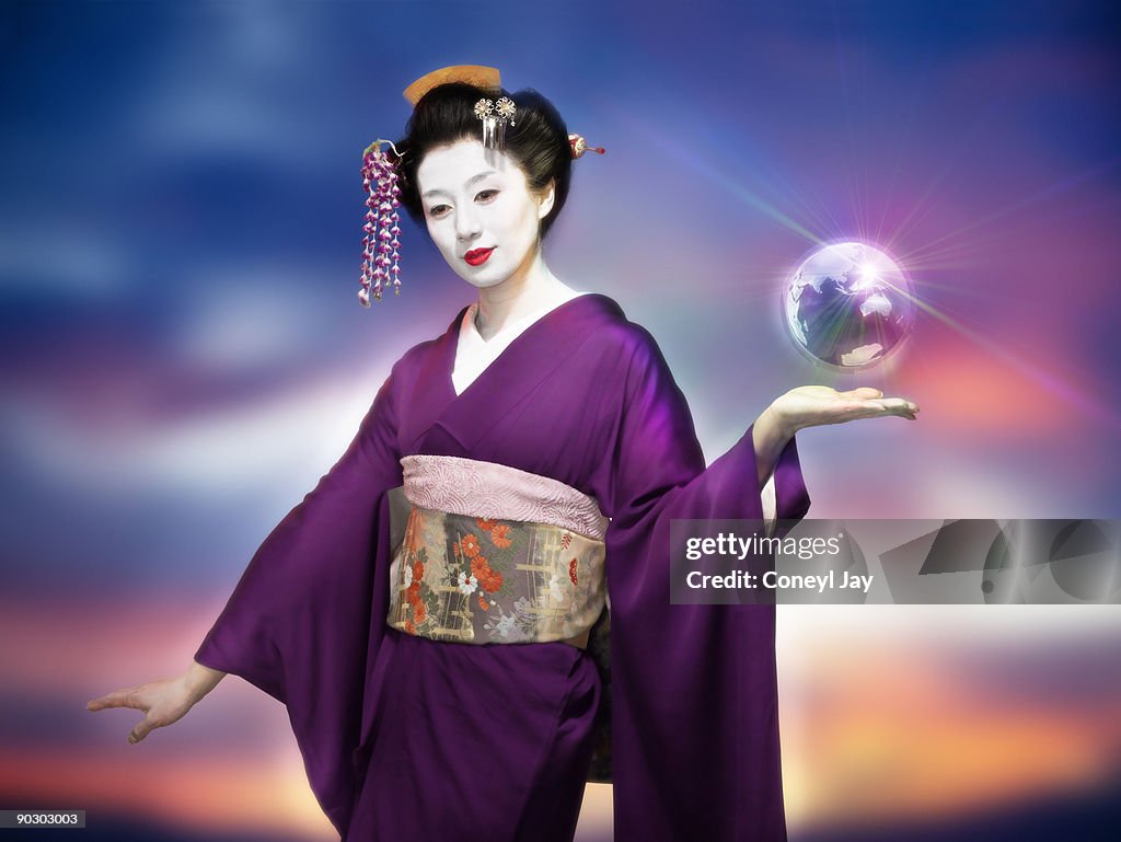 Geisha holding a small metallic floating globe