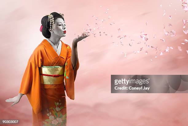 geisha blowing many cherry blossom petals - jay luck stock pictures, royalty-free photos & images
