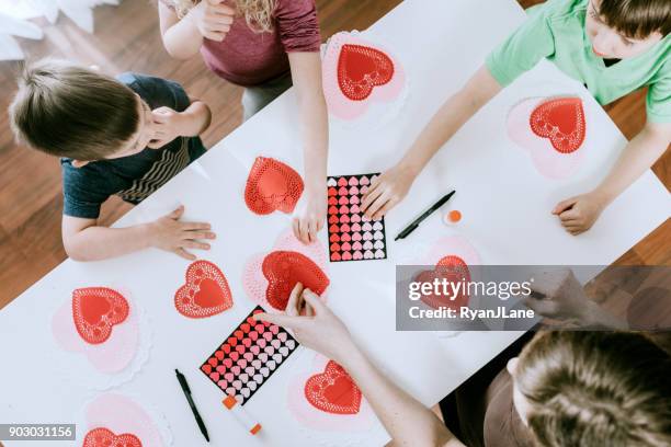 family making valentine's day cards overhead - art and craft stock pictures, royalty-free photos & images