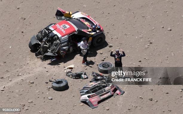 Peugeot's French driver Cyril Despres and co-driver David Castera react after a crash during Stage 4 of the Dakar 2018 in and around San Juan De...