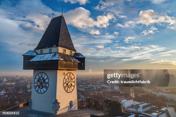 graz clock tower in golden afternoon light - graz stock pictures, royalty-free photos & images