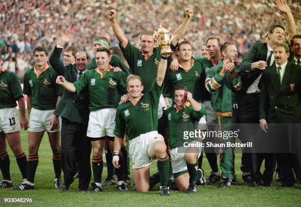 South Africa captain Francois Pienaar holds aloft the Webb Ellis trophy as the rest of the team celebrate after their 1995 World Cup Final victory...