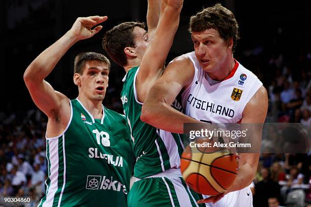 Patrick Femerling of Germany is challenged by Goran Dragic and Gasper Vidmar of Slovenia during the Basketball International friendly match between...