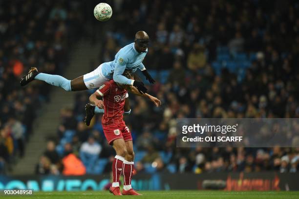 Manchester City's French defender Eliaquim Mangala wins a header from Bristol City's English striker Bobby Reid during the English League Cup...