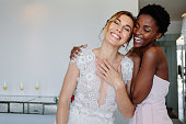 Cheerful bride and bridesmaid on the wedding day