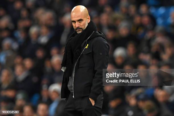 Manchester City's Spanish manager Pep Guardiola looks on during the English League Cup semi-final first leg football match between Manchester City...
