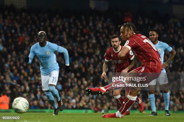 Bristol City's English striker Bobby Reid scores the opening goal from the penalty spot during the English League Cup semi-final first leg football...