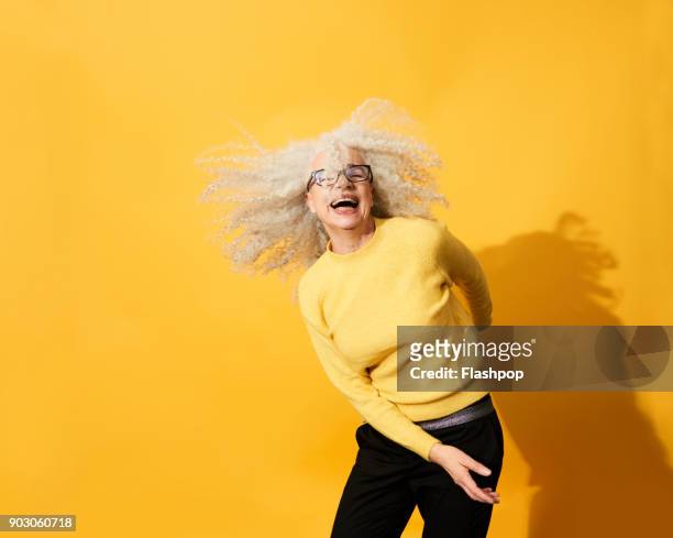 portrait of mature woman dancing, smiling and having fun - top garment stock pictures, royalty-free photos & images