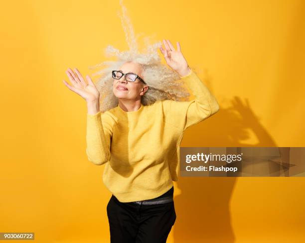 portrait of mature woman dancing, smiling and having fun - só uma mulher idosa imagens e fotografias de stock