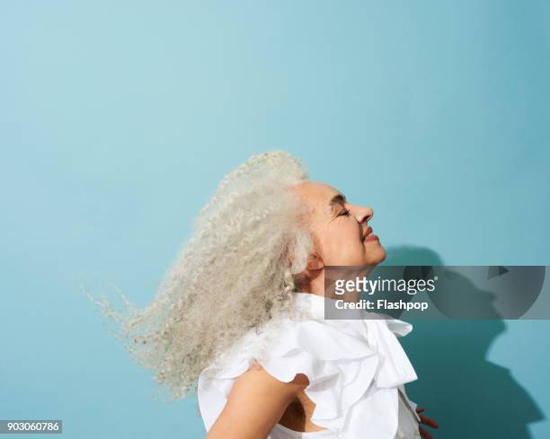 portrait of mature woman dancing, smiling and having fun - gray hair fotografías e imágenes de stock