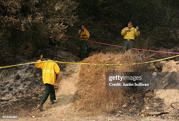 Forest Service firefighters and law enforcement officials investigate the ignition point of the Station Fire on Angeles Crest Highway September 2,...