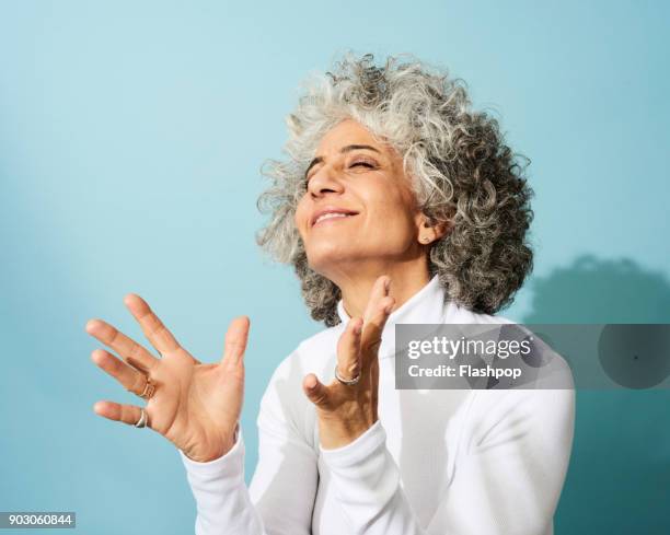 portrait of mature woman dancing, smiling and having fun - daydreaming woman stock-fotos und bilder