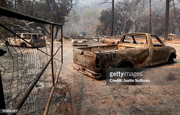 Charred cars sit near a burned down home September 2, 2009 at Vogel Flats near Tujunga, California. Fire officials said that the deadly 140,000 acre...