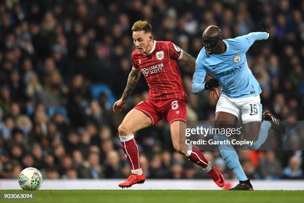 Josh Brownhill of Bristol City and Eliaquim Mangala of Manchester City chase the ball during the Carabao Cup Semi-Final First Leg match between...