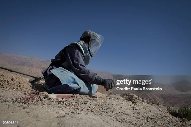 An Afghan deminer digs searching for mines and other munitions on top the archaelogical site of Shahr-i-Gholghola September 2 , 2009 in Bamiyan,...