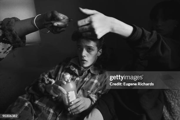 View of a seventeen-year-old girl as she watches as her friends pass around a crack pipe in an apartment at the Red Hook Houses, Brooklyn, New York,...