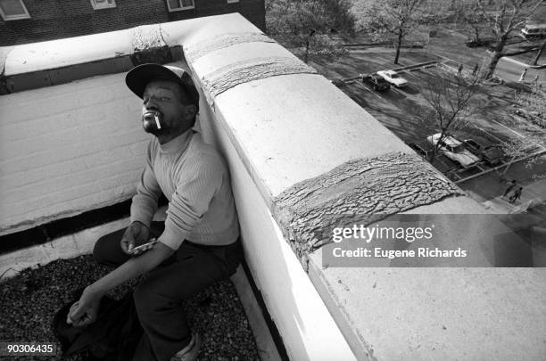 View of a man as he injects a syringe of heroin on a rooftop of the Red Hook Houses, Brooklyn, New York, New York, April 1988. The photo was part of...