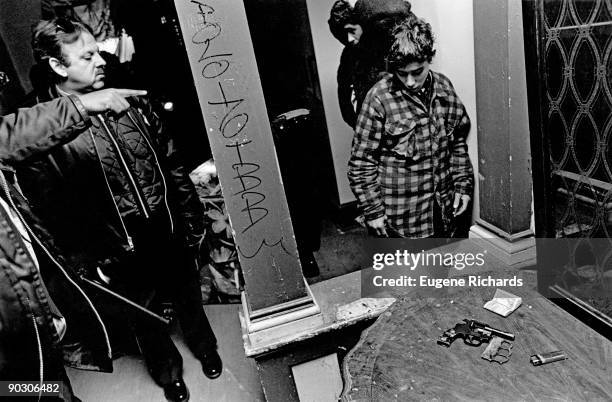 View of police officers, along with a thirteen-year-old boy , in a crack house on Mutter Street, North Philadelphia, Pennsylvania, November 1989....