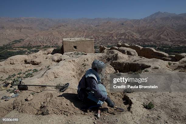 An Afghan deminer uses a small shovel to search for ordinance on top the archaelogical site of Shahr-i-Gholghola September 2 , 2009 in Bamiyan,...