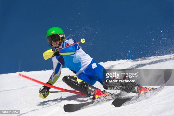 vista frontal de la joven esquiadora femenino en entrenamiento de esquí slalom - eslalon fotografías e imágenes de stock
