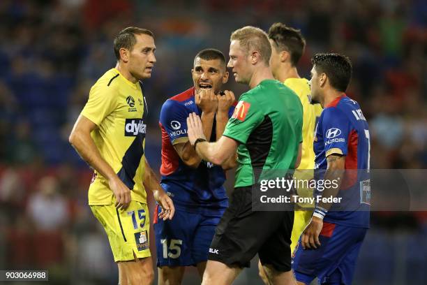 The referee talks to Alan Baro of the Mariners and Andrew Nabbout of the Jets during the round 15 A-League match between the Newcastle Jets and the...