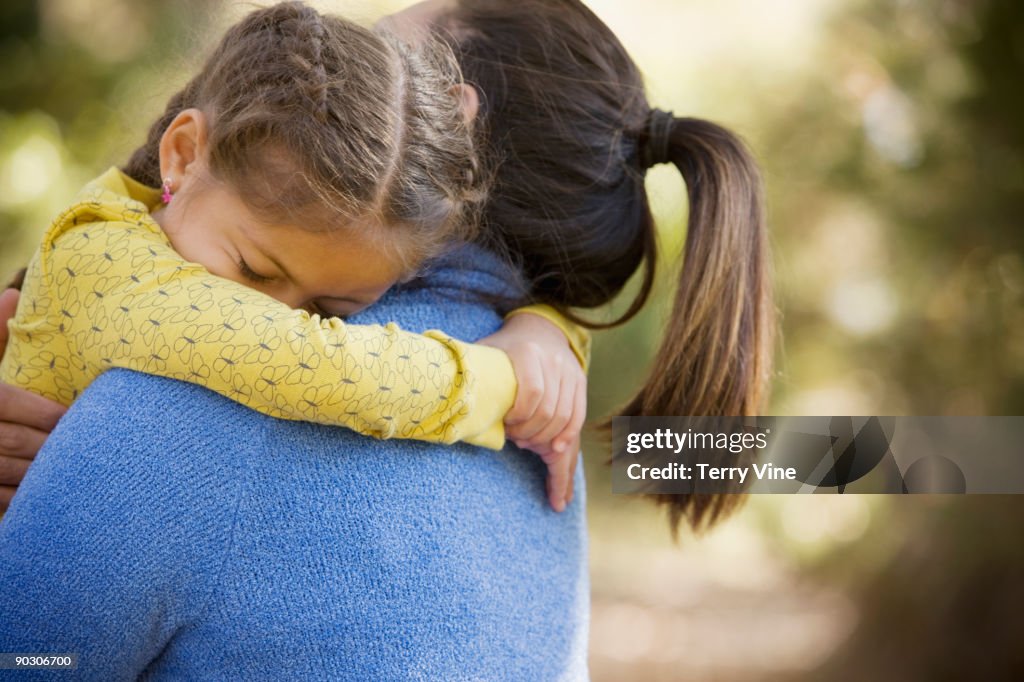 Hispanic woman carrying daughter