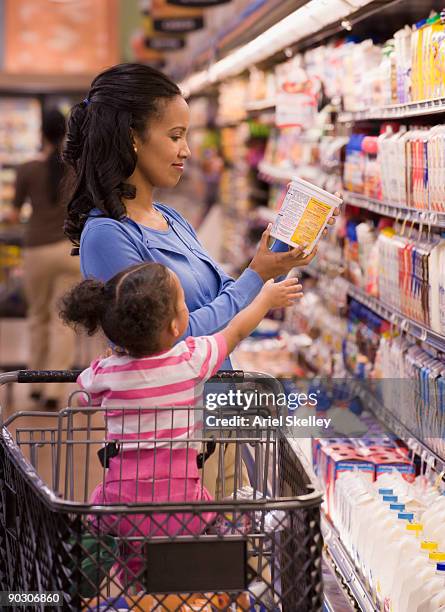 mixed race woman shopping with daughter in grocery store - tag 2 stock pictures, royalty-free photos & images