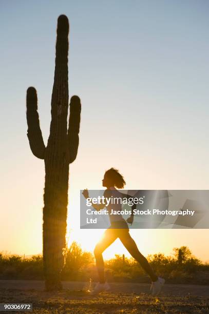 african woman running on remote road - phoenix arizona sunset stock pictures, royalty-free photos & images