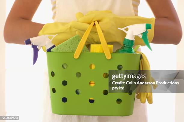 hispanic woman carrying cleaning supplies - washing up glove - fotografias e filmes do acervo