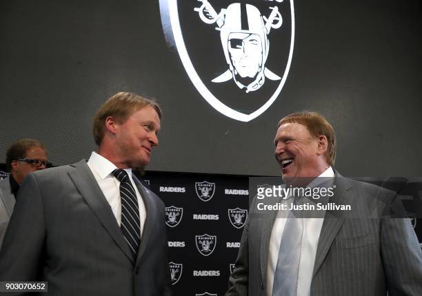 Oakland Raiders new head coach Jon Gruden talks with Raiders owner Mark Davis during a news conference at Oakland Raiders headquarters on January 9,...