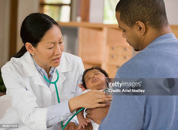 newborn getting medical checkup from doctor - examining newborn stock pictures, royalty-free photos & images