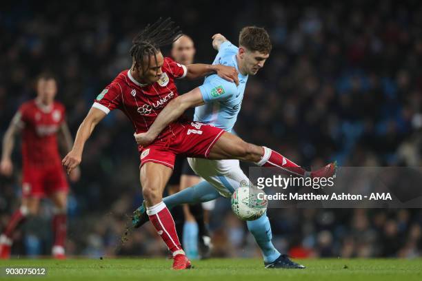 John Stones of Manchester City battles for the ball with Bobby Reid of Bristol City during the Carabao Cup Semi-Final first leg match between...