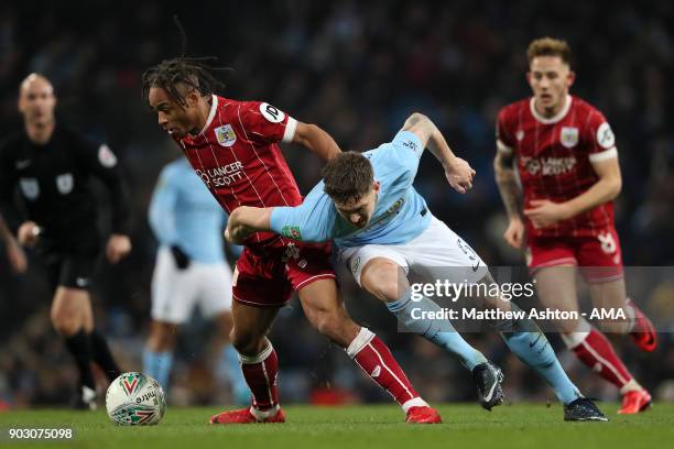 John Stones of Manchester City battles for the ball with Bobby Reid of Bristol City during the Carabao Cup Semi-Final first leg match between...