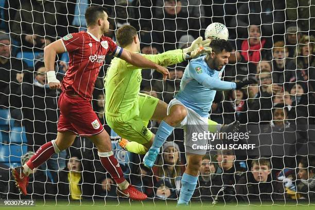 Manchester City's Argentinian striker Sergio Aguero connects with this header to score their late winning goal past Bristol City's English goalkeeper...