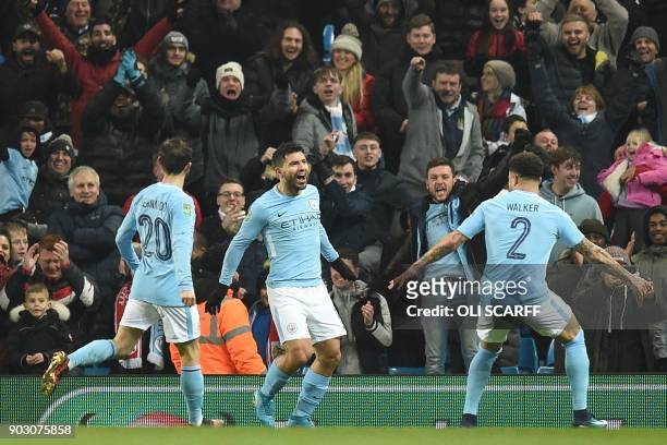 Manchester City's Argentinian striker Sergio Aguero celebrates with teammates after scoring their late winning goal during the English League Cup...