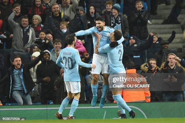 Manchester City's Argentinian striker Sergio Aguero celebrates with teammates after scoring their late winning goal during the English League Cup...