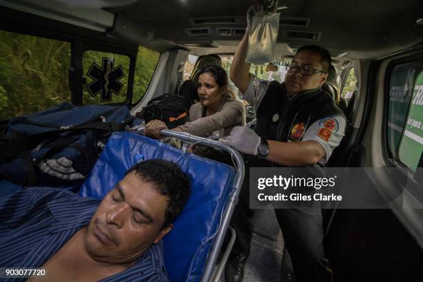 Volunteer paramedic holds up an intravenous drip on the way to a hospital in Zone 18. Guatemala City has one of highest crime/murder rates in the...