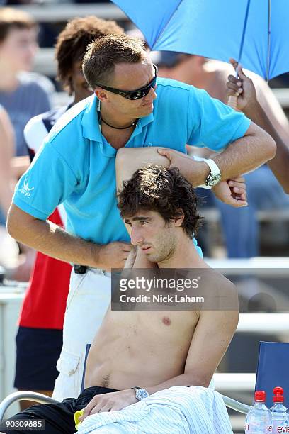 Pablo Cuevas of Uruguay stretches during a break in his match against Chris Guccione of Australia of during day three of the 2009 U.S. Open at the...