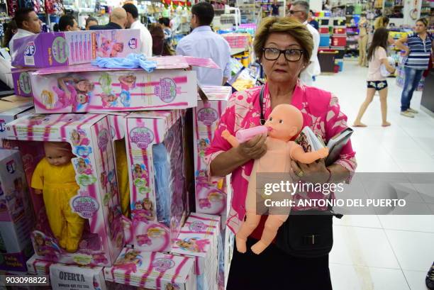 Woman holds up a "trans" doll with a penis on January 9, 2018 in Ciudad del Este, Paraguay. Customs officials in Ciudad del Este, 322 km from the...