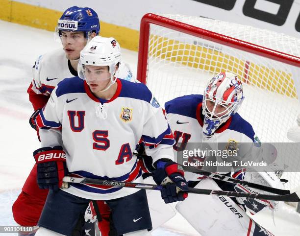 Jake Oettinger of United States looks for the puck around Josh Norris of the United States and Krystof Hrabik of Czech Republic during the first...