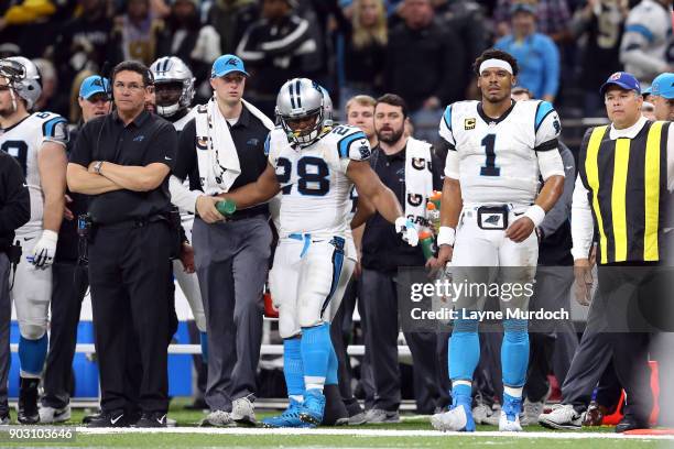 Cam Newton of the Carolina Panthers watches from the sidelines with head coach Ron Rivera against the New Orleans Saints during the second half of...