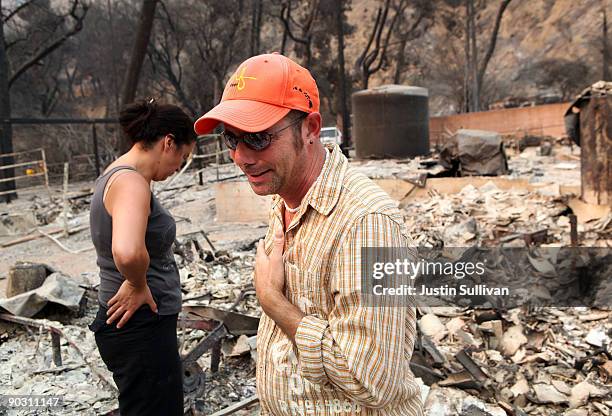 Resident, who would only give his name as Adi , cries as he looks through the charred remains of his home that was burned by the Station Fire...