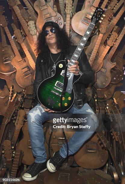 Recording artist Slash holds a one of a kind "Gibson Les Paul Slash Anaconda Burst" guitar presented to him during the Gibson rocks opening of CES...