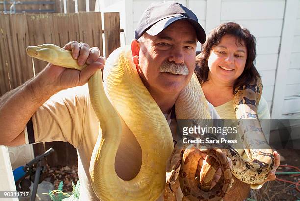 couple with snakes - pet snake stock pictures, royalty-free photos & images