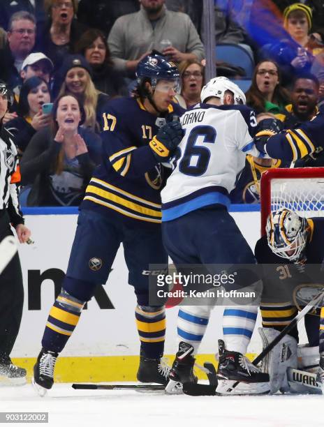 Jordan Nolan of the Buffalo Sabres gets a roughing penalty and a 10 minute misconduct against Marko Dano of the Winnipeg Jets in the second period at...