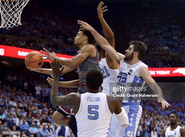 Jerome Robinson of the Boston College Eagles drives between Luke Maye and Jalek Felton of the North Carolina Tar Heels during their game at the Dean...