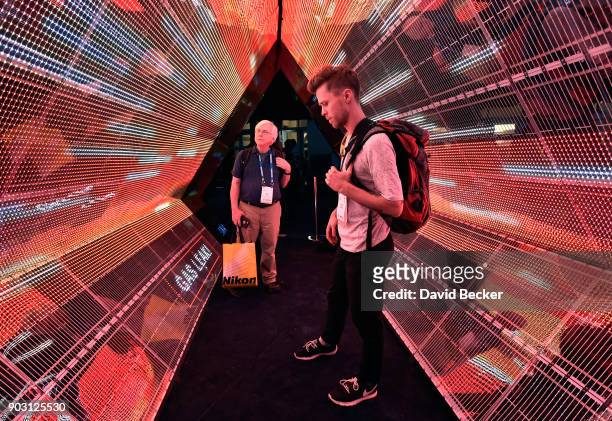 Attendees examine a 5G immersion display at the Intel booth during CES 2018 at the Las Vegas Convention Center on January 9, 2018 in Las Vegas,...
