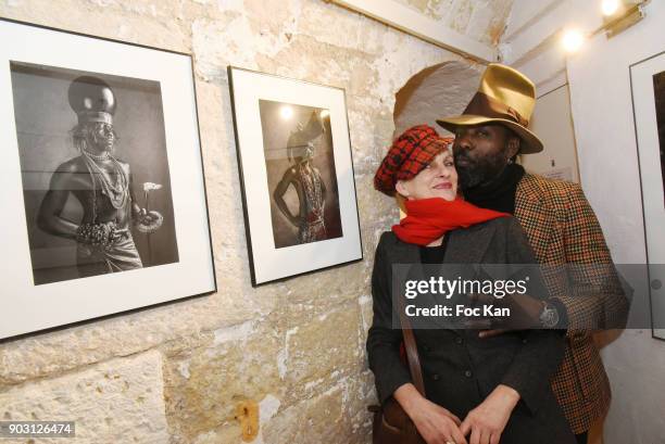 Photographer Lea Lund and Model Erik K pose with the work of Lea Lund during the 'Dandys et Sapeurs d Afrique' Exhibition Preview at Mu Gallery on...