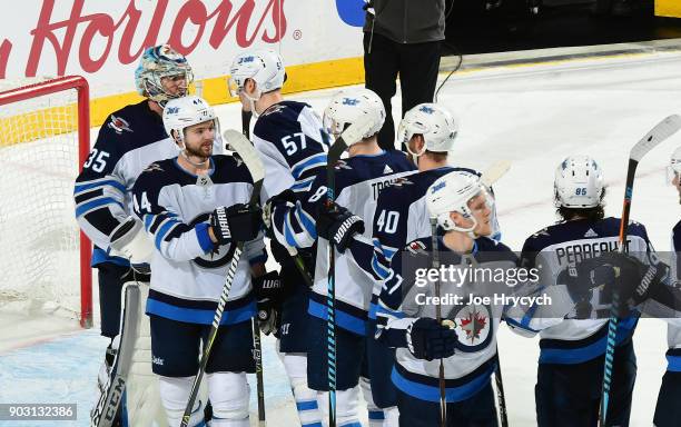 The Winnipeg Jets congratulate goaltender Steve Mason following their 7-4 victory over the Buffalo Sabres in an NHL game on January 9, 2018 at...